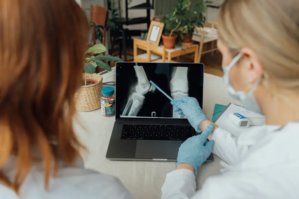 Röntgenbild einer Hand wird am Laptop besprochen